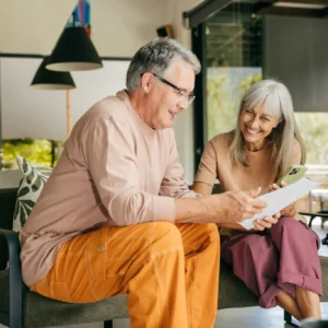 Elderly couple happily looking at a photo album together at home.
